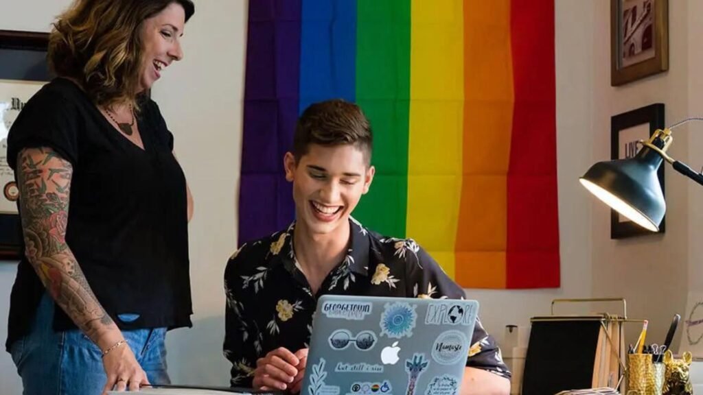 a man on a laptop, a lady standing besides him showing the best public awareness techniques 